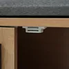 A close-up view of a furniture component, showing a magnetic catch attached to a wooden shelf. Produktbild-Vorschau