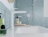 A modern bathroom sink area with a white faucet, soap dispensers, and a tiled wall. Voir les images du produit