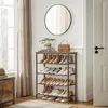 A shoe rack filled with shoes, placed next to a window with curtains and a mirror on the wall. Anteprima dell’immagine prodotto