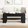 A black coffee table is placed in front of a white sofa in a living room setting. Náhled obrázku produktu