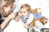 A mother is taking her child's temperature with a digital thermometer. Produktbild-Vorschau