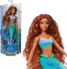 A doll in packaging and a close-up of the doll. Voir les images du produit
