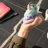 A hand is squeezing a colorful stress toy shaped like a unicorn poop. Voir les images du produit