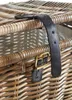 A close-up view of a wicker basket with leather straps and a brass buckle. Podgląd zdjęcia produktu