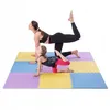 A woman and a child are doing yoga on a colorful puzzle mat. Voir les images du produit