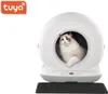 A cat sits inside a modern, white, spherical automatic cat litter box. A black mat is placed in front of the litter box. Náhľad obrázku produktu