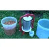 An apple press and buckets of crushed apples are set up on a grassy lawn. Produktbild-Vorschau