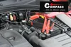 A car engine bay with a COMPASS power bank jump starter connected to the battery. Náhľad obrázku produktu