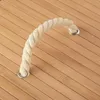 A close-up view of a rope handle attached to a wooden surface. Voir les images du produit