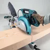A person wearing a glove is using a Makita miter saw to cut a piece of wood. Anteprima dell’immagine prodotto