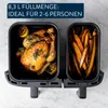 A split image showing a whole roasted chicken with lemon in one compartment of an air fryer and sweet potato fries in the other. Produktbild-Vorschau