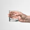 A hand holding a clear glass. Anteprima dell’immagine prodotto