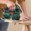 A person is using a Bosch jigsaw to cut a piece of wood. Náhled obrázku produktu