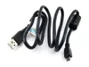 A black USB cable is coiled on a white background. Voir les images du produit