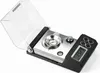A close-up of a digital milligram scale with a clear cover lifted. Voir les images du produit