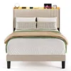 A bed with bedding and decorative pillows, set against a white background. The headboard has a built-in shelf with illuminated elements and several electronic devices. Produktbild-Vorschau
