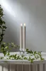 Two LED candles in glass holders on a white surface with ivy vines. Produktbild-Vorschau