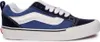 A side view of a blue and navy Vans sneaker with white laces and a white sole. Náhled obrázku produktu