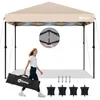 A woman is walking and carrying a folded canopy in a bag, with the canopy set up in the background. Accessories like sandbags and stakes are also displayed. Produktbild-Vorschau
