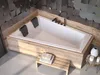 A modern bathroom with a built-in bathtub, wooden accents, and decorative wall tiles. Produktbild-Vorschau