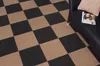 Selbstklebende Teppichfliesen in einem Schachbrettmuster verlegt in einem Flur. Produktbild-Vorschau