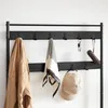 A close-up shot of a black wooden coat rack with various items hanging on it. Produktbild-Vorschau