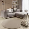 A modern living room scene with a sectional sofa, decorative pillows, a round rug, and shelves with decor. Náhľad obrázku produktu