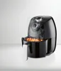 A black air fryer with food inside, emitting steam. Produktbild-Vorschau