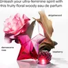 A perfume bottle with floral and woody elements, along with fruit elements, is presented in a visually appealing arrangement. Podgląd zdjęcia produktu