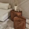 A living room scene with a sofa and two round wooden side tables. Produktbild-Vorschau
