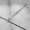 A close-up view of a shower wall support bar attached to a glass shower door, with tiled walls in the background. Produktbild-Vorschau