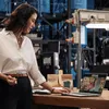 A woman is on a video call on her laptop in what appears to be a factory or workshop setting. Voir les images du produit