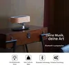 A wooden speaker with a tree-like stand on a vintage wooden table. Produktbild-Vorschau