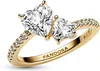 A close-up studio shot of a gold Pandora ring with two heart-shaped clear stones and small clear stones along the band. Produktbild-Vorschau
