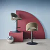 Two khaki bar stools are displayed in a studio setting with a red curved backdrop and a disco ball. Produktbild-Vorschau