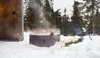 People relaxing in a hot tub in a snowy forest setting. Produktbild-Vorschau