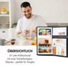 A man is preparing breakfast in a kitchen, with a small refrigerator open next to him. Produktbild-Vorschau