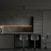 A modern, dark-themed kitchen with bar stools in the foreground. Voir les images du produit