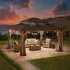 A gazebo with outdoor furniture set up on a patio at dusk, with a view of the ocean and hills in the background. Produktbild-Vorschau