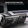 A black phone case with a ring stand is shown in the foreground, with a laptop and headphones in the background. Produktbild-Vorschau