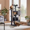 Three cats interact with a multi-level cat tree in a living room setting. Produktbild-Vorschau
