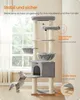 A cat tree with a cat playing near it, in a room with a window. Produktbild-Vorschau