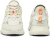 Front and back views of a pair of cream-colored Lacoste sneakers with orange accents. Produktbild-Vorschau