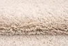 A close-up view of a beige shaggy rug. Anteprima dell’immagine prodotto