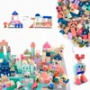 A collage of wooden building blocks arranged to form a city scene, including buildings, vehicles, and a robot figure, along with a separate pile of loose blocks. Náhled obrázku produktu