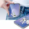 A hand places a smartphone with a screen protector and keys into a jeans pocket, while another smartphone with keys rests in the foreground. Produktbild-Vorschau