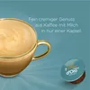 A close-up of a coffee cup with latte art and a coffee capsule on a teal background. Produktbild-Vorschau