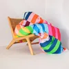 A colorful striped duvet cover is draped over a wooden chair. Voir les images du produit