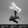 A white clip-on lamp with a black clip and adjustable neck, shown against a plain gray background. Icons and text describing features are present at the bottom. Produktbild-Vorschau