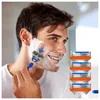 A man is shaving his face with a Gillette razor, with replacement blades shown to the right. Produktbild-Vorschau